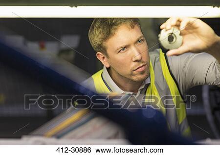 Focused worker inspecting part in steel factory View Large Photo Image Stock Photograph - Focused worker inspecting part in steel factory. Fotosearch