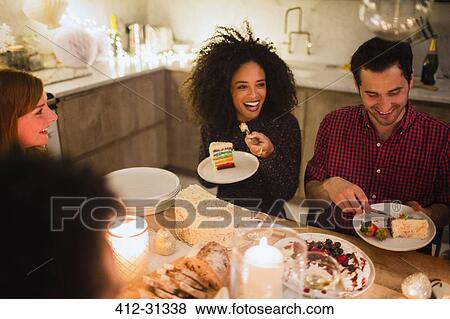 Friends eating cake at candlelight table View Large Photo Image Stock Photo - Friends eating cake at candlelight table. Fotosearch