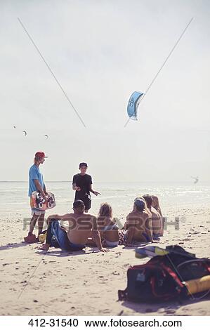 Friends learning kiteboarding on sunny beach View Large Photo Image Stock Image - Friends learning kiteboarding on sunny beach. Fotosearch