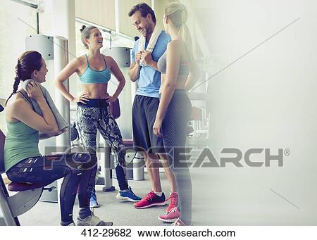 Stock Image - Friends talking and resting at gym. Fotosearch