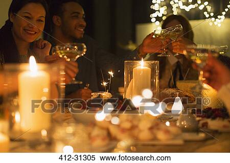 Friends toasting champagne glasses at candlelight Christmas table View Large Photo Image Stock Photography - Friends toasting champagne glasses at candlelight Christmas table. Fotosearch