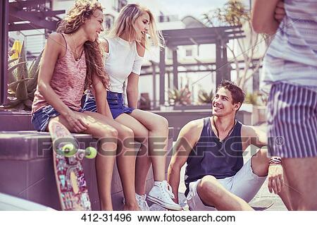 Stock Photograph - Friends with skateboard hanging out. Fotosearch