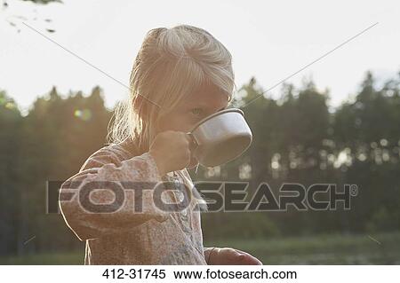 Stock Photography - Girl drinking from camping cup. Fotosearch