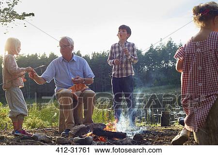 Grandfather and grandchildren enjoying campfire at lakeside View Large Photo Image Stock Image - Grandfather and grandchildren enjoying campfire at lakeside. Fotosearch