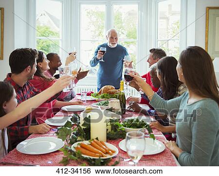 Grandfather making toast with wine at Christmas dinner table View Large Photo Image Stock Photograph - Grandfather making toast with wine at Christmas dinner table. Fotosearch
