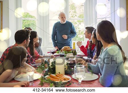 Grandfather preparing to carve Christmas turkey at dinner table View Large Photo Image Picture - Grandfather preparing to carve Christmas turkey at dinner table. Fotosearch