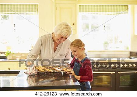 Grandmother and granddaughter baking gingerbread cookies in kitchen View Large Photo Image Stock Image - Grandmother and granddaughter baking gingerbread cookies in kitchen. Fotosearch