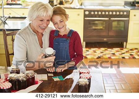 Grandmother and granddaughter canning jam in kitchen View Large Photo Image Stock Image - Grandmother and granddaughter canning jam in kitchen. Fotosearch