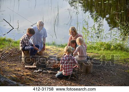 Grandparents and grandchildren enjoying campfire at lakeside View Large Photo Image Stock Photo - Grandparents and grandchildren enjoying campfire at lakeside. Fotosearch