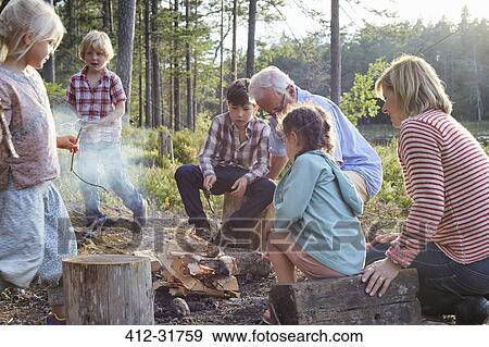 Grandparents and grandchildren enjoying campfire at lakeside View Large Photo Image Stock Photo - Grandparents and grandchildren enjoying campfire at lakeside. Fotosearch