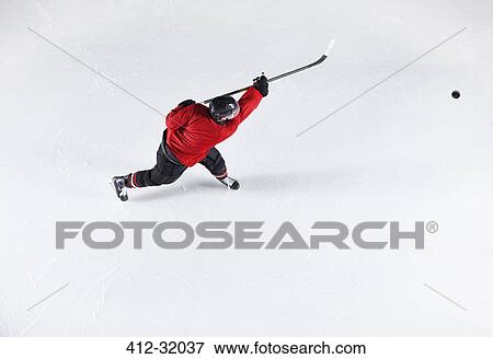 Hockey player in red uniform shooting puck on ice View Large Photo Image Stock Photo - Hockey player in red uniform shooting puck on ice. Fotosearch