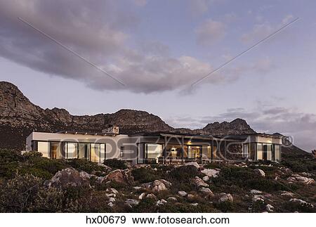 Home showcase exterior on craggy hillside under clouds at dusk View Large Photo Image Stock Photo - Home showcase exterior on craggy hillside under clouds at dusk. Fotosearch