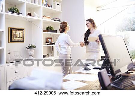 Stock Photography - Interior designer and client handshaking in office. Fotosearch