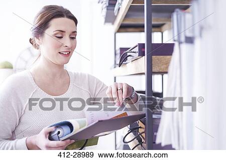 Interior designer browsing fabric swatches in office View Large Photo Image Stock Photo - Interior designer browsing fabric swatches in office. Fotosearch