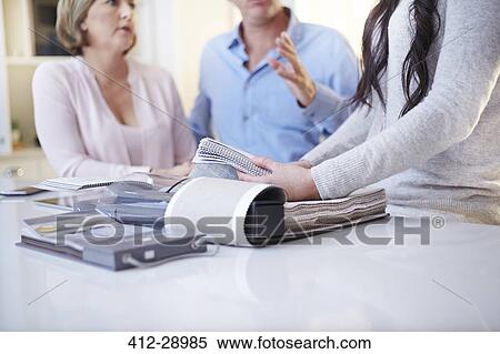 Interior designer discussing swatches with couple in consultation View Large Photo Image Stock Photography - Interior designer discussing swatches with couple in consultation. Fotosearch
