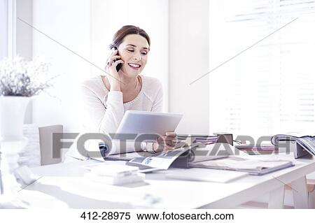 Interior designer talking on cell phone and using digital tablet in office with swatches View Large Photo Image Stock Photography - Interior designer talking on cell phone and using digital tablet in office with swatches. Fotosearch