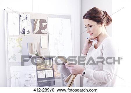 Stock Image - Interior designer viewing swatches in office. Fotosearch