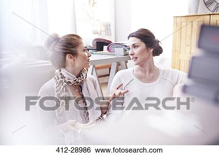 Stock Photograph - Interior designers talking in office. Fotosearch