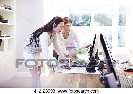 Stock Image - Interior designers using computer in office. Fotosearch