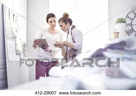 Interior designers with digital tablet discussing swatches in office View Large Photo Image Stock Photo - Interior designers with digital tablet discussing swatches in office. Fotosearch