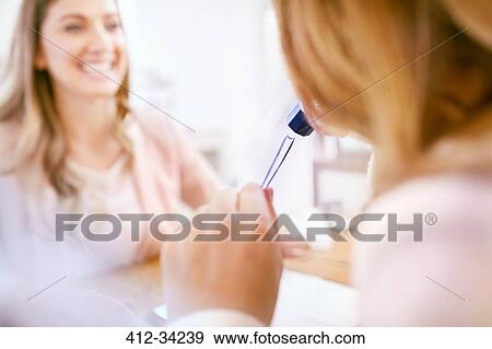 Jeweler helping woman shopping using loupe View Large Photo Image Stock Photo - Jeweler helping woman shopping using loupe. Fotosearch