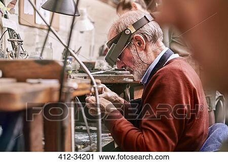 Jeweler wearing headband magnifier working in workshop View Large Photo Image Stock Image - Jeweler wearing headband magnifier working in workshop. Fotosearch