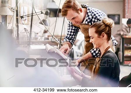 Jewelers reviewing plans in workshop View Large Photo Image Stock Photo - Jewelers reviewing plans in workshop. Fotosearch