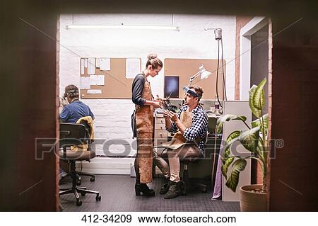Stock Photo - Jewelers talking in workshop office. Fotosearch