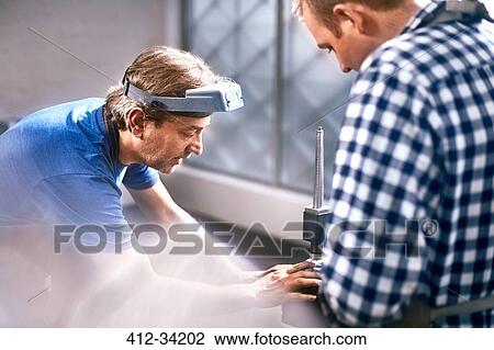 Stock Image - Jewelers using equipment in workshop. Fotosearch