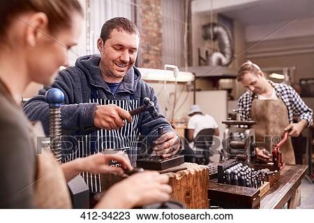 Stock Image - Jewelers using equipment in workshop. Fotosearch