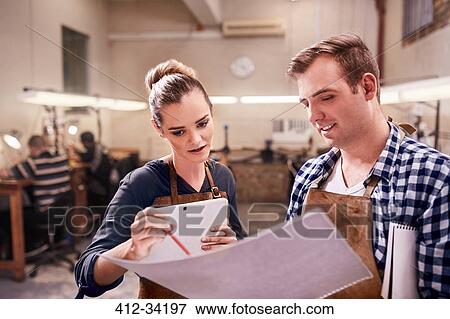 Jewelers with digital tablet and blueprints in workshop View Large Photo Image Stock Photo - Jewelers with digital tablet and blueprints in workshop. Fotosearch