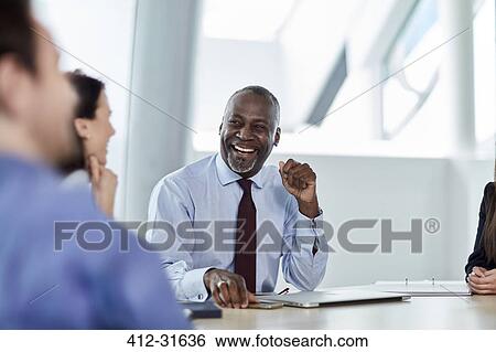 Stock Photograph - Laughing businessman enjoying meeting. Fotosearch
