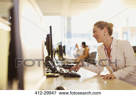 Laughing businesswoman working at computer in office View Large Photo Image Stock Photo - Laughing businesswoman working at computer in office. Fotosearch