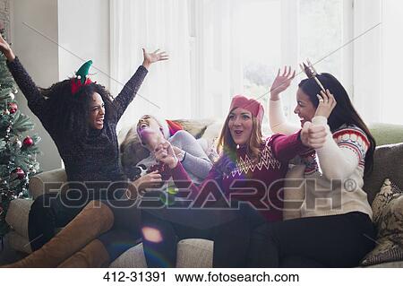 Laughing friends celebrating Christmas on sofa View Large Photo Image Stock Image - Laughing friends celebrating Christmas on sofa. Fotosearch