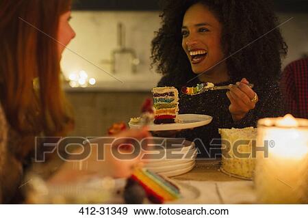 Laughing friends enjoying cake at candlelight table View Large Photo Image Stock Photo - Laughing friends enjoying cake at candlelight table. Fotosearch