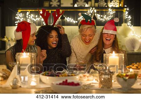 Laughing friends enjoying candlelight Christmas dinner View Large Photo Image Picture - Laughing friends enjoying candlelight Christmas dinner. Fotosearch