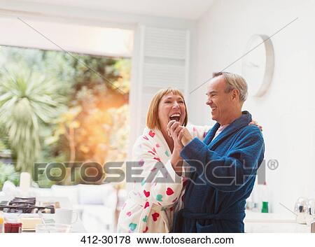 Stock Photo - Laughing mature couple dancing in bathrobes at home. Fotosearch