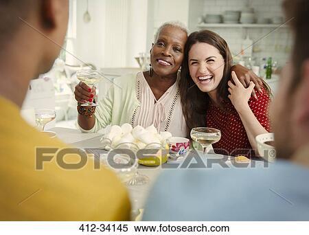 Stock Photography - Laughing women toasting champagne at party. Fotosearch