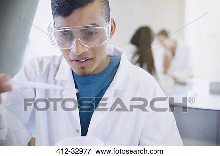 Stock Photo - Male college student conducting scientific experiment in science laboratory classroom. Fotosearch