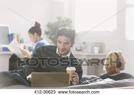 Male college student drinking coffee at laptop View Large Photo Image Stock Image - Male college student drinking coffee at laptop. Fotosearch