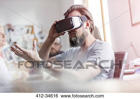 Male design professional using virtual reality simulator glasses in office View Large Photo Image Stock Photograph - Male design professional using virtual reality simulator glasses in office. Fotosearch