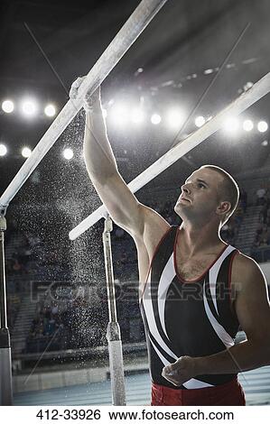 Male gymnast applying chalk powder to parallel bars in arena View Large Photo Image Stock Photograph - Male gymnast applying chalk powder to parallel bars in arena. Fotosearch