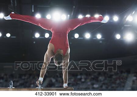 Male gymnast performing upside-down handstand on pommel horse View Large Photo Image Stock Image - Male gymnast performing upside-down handstand on pommel horse. Fotosearch
