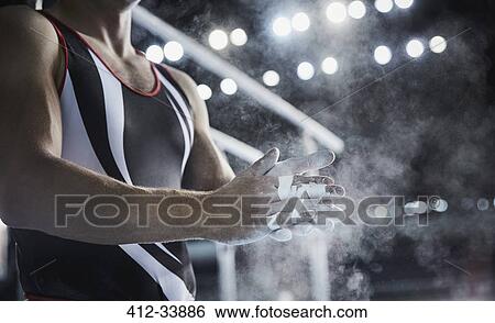 Male gymnast rubbing chalk powder on hands below parallel bars View Large Photo Image Stock Photograph - Male gymnast rubbing chalk powder on hands below parallel bars. Fotosearch