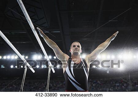 Male gymnast with arms raised next to parallel bars View Large Photo Image Stock Image - Male gymnast with arms raised next to parallel bars. Fotosearch