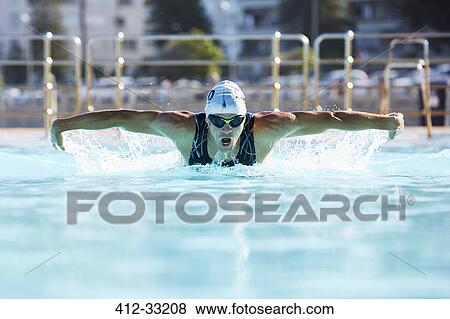Stock Photo - Male swimmer athlete doing butterfly stroke swimming in swimming pool. Fotosearch