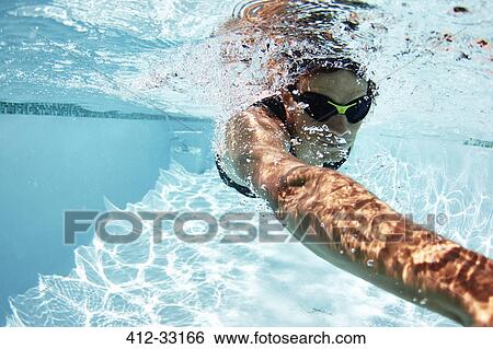 Stock Photograph - Male swimmer athlete swimming underwater in swimming pool. Fotosearch