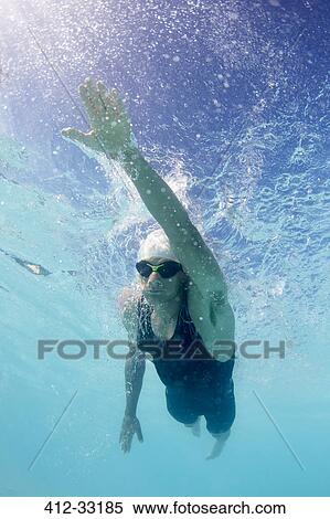 Stock Photography - Male swimmer athlete swimming underwater in swimming pool. Fotosearch