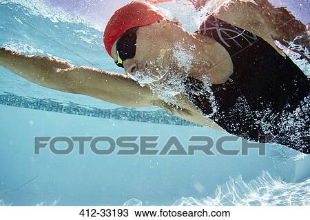 Male swimmer swimming underwater in swimming pool View Large Photo Image Stock Image - Male swimmer swimming underwater in swimming pool. Fotosearch