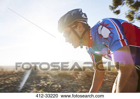 Male triathlete cyclist cycling at sunrise View Large Photo Image Stock Image - Male triathlete cyclist cycling at sunrise. Fotosearch